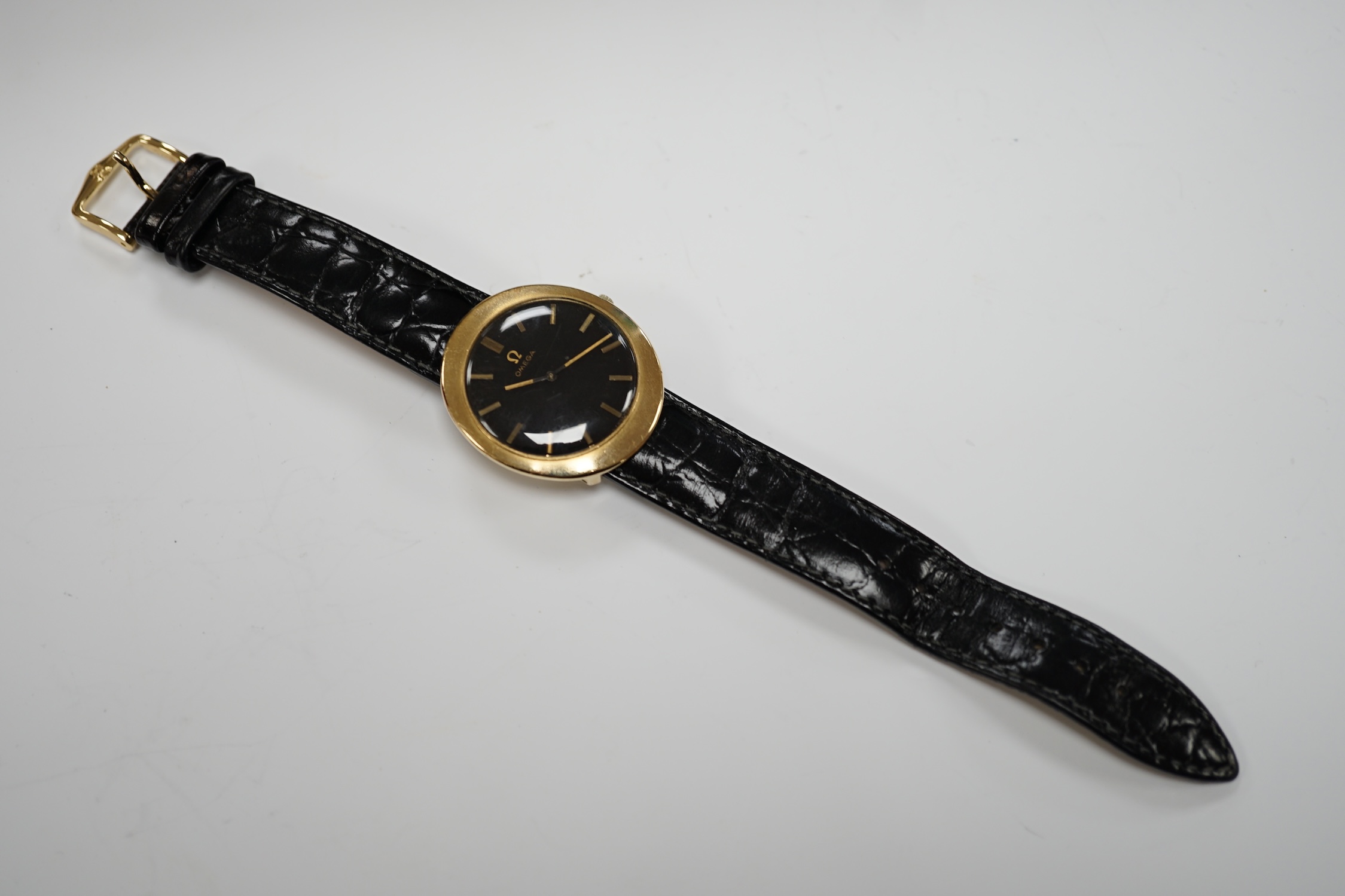 A gentleman's 9ct gold black dial manual wind wrist watch, with Omega box.